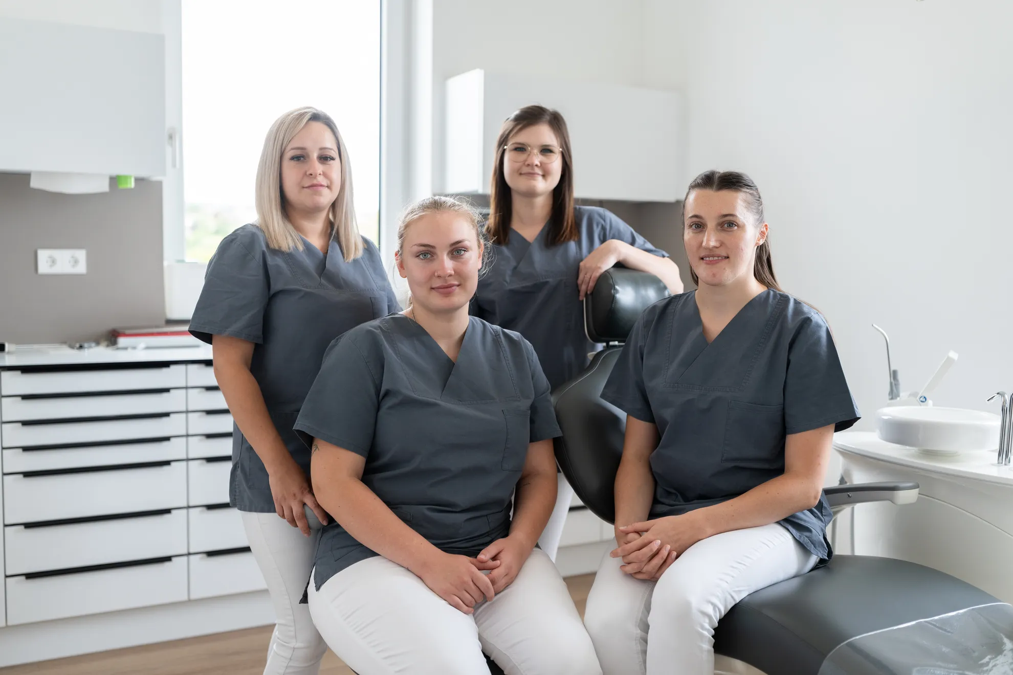Gruppenbild mit vier Zahnmedizinischen Fachangestellten im Behandlungszimmer